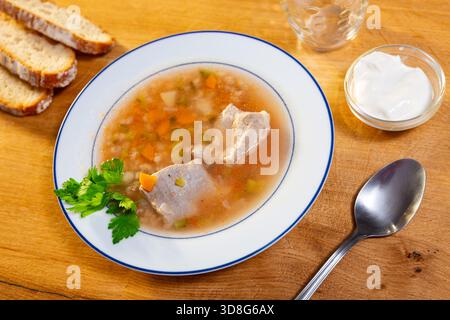 Leckere Suppe Rassolnik serviert in einer Schüssel auf dem Tisch, dekoriert mit Petersilie. Traditionelles russisches Gericht Stockfoto