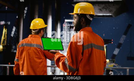Isolierter Chroma-Schlüssel mit Mitarbeitern, die Ölbohrungen auf Offshore-Plattformen überwachen und Technologien zur Gewinnung von Erdgas und fossilen Brennstoffen aus dem Ökosystem des Ozeans einsetzen. Stockfoto