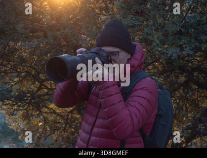 678 / 5.000 Tierfotograf bei der Golden Hour mit professioneller Digitalkamera Stockfoto