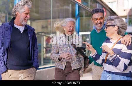 Glückliche Seniorenfreunde, die draußen zusammen lachen Stockfoto