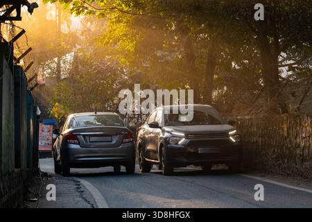 Zwei Autos fahren vorsichtig auf einer schmalen Einbahnstraße in Indien vorbei Stockfoto
