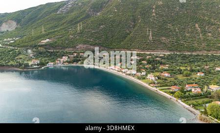 Aus der Vogelperspektive von Skaloma, einem Küstendorf in Zentralgriechenland, zeigt die Küste des Golfs von Korinth, das klare blaue Meer und traditionelle Häuser. Stockfoto