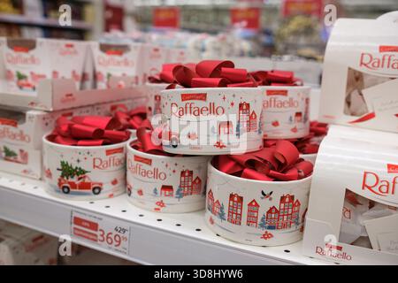 30. November 2025, Moskau, Russland. Festlich verpackte Raffaello-Boxen sind ordentlich in den Regalen angeordnet und ziehen die Aufmerksamkeit der Urlaubskäufer auf sich Stockfoto