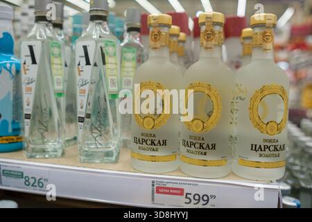30. November 2025, Moskau, Russland. Mehrere Wodka-Flaschen stehen in den Regalen des Stores mit Preisangaben, die ihre Kosten angeben. Stockfoto