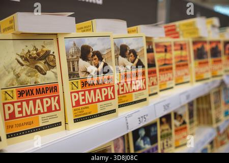 30. November 2025, Moskau, Russland. Eine bunte Ausstellung von Büchern von Erich Maria Remarque füllt ein Regal in einem Buchladen. Stockfoto