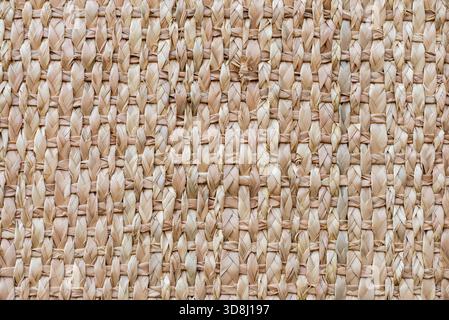 Detaillierte Nahaufnahme einer gewebten Korboberfläche, die die natürliche Textur und das komplizierte Muster des Webens zeigt. Stockfoto