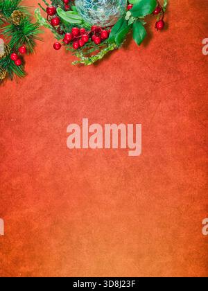 Festliches Weihnachtsdekor roter Hintergrund - festliche Weihnachtsdekorationen, einschließlich einem Kieferkranz, roten Beeren und einem einzigartigen Glasschmuck, auf einer Vibran Stockfoto