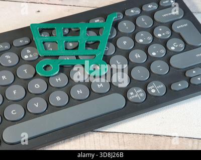 Einkaufswagen-Symbol auf der Tastatur – grünes 3D-gedrucktes Einkaufswagen-Symbol auf einer modernen Computertastatur, symbolisiert Online-Shopping, E-Commerce, A Stockfoto