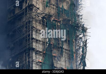 (251201) -- HONGKONG, 1. Dezember 2025 (Xinhua) -- Ein Gebäude im Wang Fuk Court wird nach einem Brand hier in Tai Po, Hongkong, Südchina, am 27. November 2025 dargestellt. Die Polizei von Hongkong hatte 13 Personen wegen mutmaßlichen Totschlags wegen des Großbrandes im Wohnkomplex Wang Fuk Court verhaftet, sagten die örtlichen Behörden bei einem Pressegespräch am Montag. Die Ermittlungen der Polizei sind noch nicht abgeschlossen, und es könnten weitere Verhaftungen geben. Sieben von 20 Proben von Baumaschen, die aus dem Komplex gesammelt wurden, erfüllten nicht die Brandschutzstandards, sagten die Behörden. Diese Stücke Netzblätter, Coupl Stockfoto