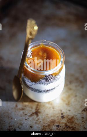 Griechischer Joghurt mit Chiasamen und Pflaumenmarmelade, serviert in einem klaren Glas, ein gesunder und köstlicher Snack Stockfoto