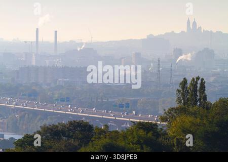 Frankreich, Ile-de-France, Paris. Autobahn A15. Basilique du Sacre-Coeur auf dem Hügel Montmartre im Hintergrund, Plan. Zwei große Schornsteine in Saint-Ouen- Stockfoto
