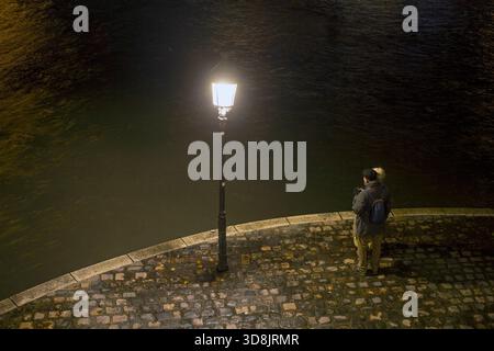 Frankreich, Paris, 75, 4. Arrondissement, Pointe avale de l'Ile St-Louis, Seniorenpaar, das die seine bei Nacht erwägt, 12/2024. Stockfoto