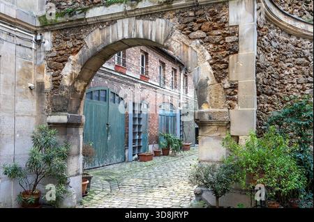Frankreich. Paris. 9. Arrondissement. Rue d'Aumale. Alter, versteckter, ruhiger und gepflasterter Innenhof Stockfoto