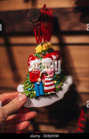 Eine Frauenhand mit einem keramischen Weihnachtsspielzeug in Form von magischen Elfen, süßer und gemütlicher Weihnachtsdekoration Stockfoto