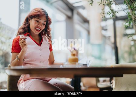 Lächelnde Kellnerin in rosa Uniform in einem Café, die einen Moment freundlichen Service genießt Stockfoto