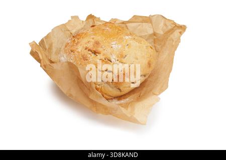 Studio-Aufnahme eines einzelnen Sauerteiglaibs, der in Backpapier gewickelt ist und vor weißem Hintergrund ausgeschnitten wurde Stockfoto