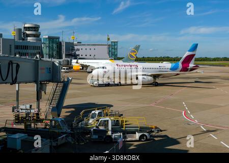 Düsseldorf, Nordrhein-Westfalen, Deutschland - Flughafen Düsseldorf, Flugzeuge Eurowings und Condor am Terminal mit Flugsicherungsturm. Stockfoto