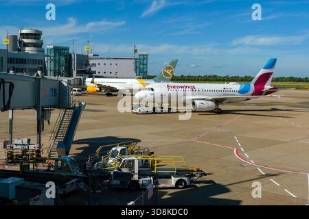 Düsseldorf, Nordrhein-Westfalen, Deutschland - Flughafen Düsseldorf, Flugzeuge Eurowings und Condor am Terminal mit Flugsicherungsturm. Stockfoto