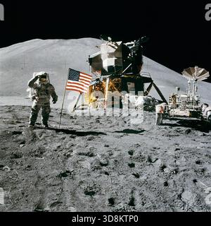 Apollo 15 Lunar Module Pilot James Irwin würdigt die US-Flagge. Der Astronaut James B. Irwin, Pilot des Mondmoduls, grüßt militärisch, während er neben der US-Flagge steht, während der Apollo 15-Mondoberfläche-außerfahrzeugsame Aktivität (EVA) am Landeplatz Hadley-Apennin. Die Flagge wurde gegen Ende von EVA-2 ausgelöst. Das Lunar Module (LM) „Falcon“ befindet sich in der Mitte. Auf der rechten Seite befindet sich das Lunar Roving Vehicle (LRV). Diese Aussicht sieht fast nach Süden aus. Das Hadley Delta im Hintergrund erhebt sich etwa 4.000 Meter (etwa 13.124 Fuß) über der Ebene. Der Fuß des Berges ist ungefähr Stockfoto