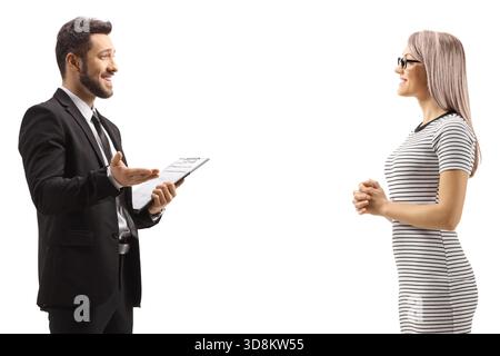 Mann in einem schwarzen Anzug, der mit einer Frau in einem lässigen Kleid auf weißem Hintergrund spricht Stockfoto