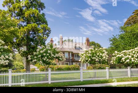 Großes East hampton Haus in einer Sommerlandschaft mit einem weißen Pfahlzaun Stockfoto