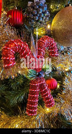 Ein Weihnachtsbaum mit verschiedenen farbenfrohen Weihnachtsspielzeugen und Dekorationselementen Stockfoto