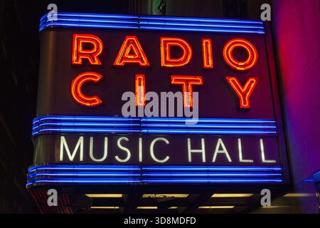 Ein Neonschild der Radio City Music Hall vor dem Rockefeller Center.z Stockfoto