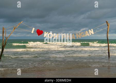 Abendliches stürmisches Meer vor Sonnenuntergang und der Inschrift Ich liebe Koh Phangan, vor Vollmondparty am Strand Haad Rin auf der tropischen Insel Koh Phangan, Stockfoto