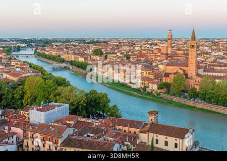 Panoramablick auf die Altstadt von Verona mit dem Fluss Etsch, historischen Dächern und Kirchtürmen bei Sonnenuntergang, Veneto, Italien. Italienische Architektur und Stockfoto