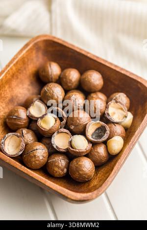Leckere Macadamia-Nüsse in einer Schüssel auf einem weißen Tisch. Stockfoto