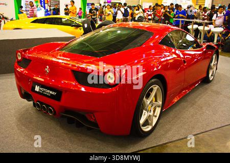 Der glänzend rote Ferrari 458 Italia wird auf der Automotive expo ausgestellt und begeistert mit seinem schlanken Design und seinem sportlichen Look die Menschenmassen. Stockfoto