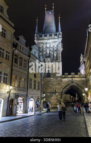 Nächtlicher Blick auf den Brückenturm der Kleinstadt, Malostranska Mostecka VGS, erbaut im spätgotischen und römisch-gotischen Stil mit Touristen auf Spaziergängen auf Mostecka Stockfoto