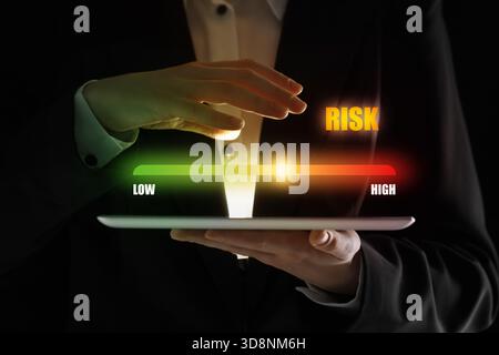 Mann reguliert das Risikoniveau auf dem virtuellen Bildschirm über dem Tablet-Computer, Nahaufnahme Stockfoto