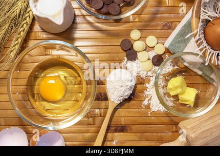 Set mit Backzutaten mit Eigelb, Mehl, Butter und Schokoladenchips auf dem Tisch. Stockfoto