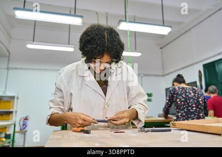 Die junge Handwerkerin konzentrierte sich darauf, handgefertigte Stücke mit Werkzeugen zu kreieren und in einem Studio Können und Handwerkskunst zu demonstrieren Stockfoto