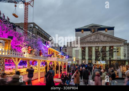 Brüssel, Belgien - 30. November 2025: Weihnachtsmarkt Chalets und beleuchtete Bäume vor dem La Monnaie Theater während der Winterwunder festlich sogar Stockfoto