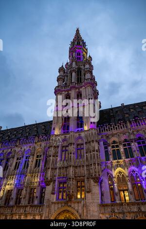 Brüssel, Belgien - 30. November 2025: Der gotische Turm des Brüsseler Rathauses leuchtet in der Abenddämmerung während der Winterwunder-Feierlichkeiten Stockfoto