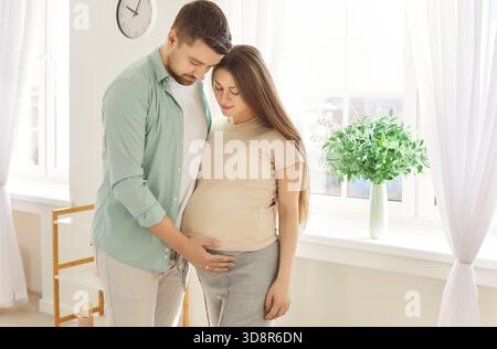 Glückliches, liebevolles Paar, das sich während der Schwangerschaft unterstützt und es genießt, auf das Baby zu warten. Stockfoto