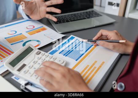 Geschäftskollegen prüfen gemeinsam Budgetdiagramme in einem modernen Büro und konzentrieren sich dabei auf finanzielle Erkenntnisse, Leistungskennzahlen und strategische Planung Stockfoto