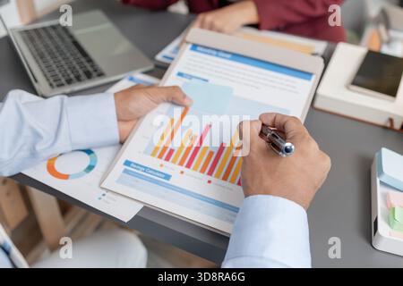 Geschäftskollegen prüfen gemeinsam Budgetdiagramme in einem modernen Büro und konzentrieren sich dabei auf finanzielle Erkenntnisse, Leistungskennzahlen und strategische Planung Stockfoto