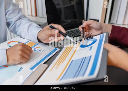 Geschäftskollegen prüfen gemeinsam Budgetdiagramme in einem modernen Büro und konzentrieren sich dabei auf finanzielle Erkenntnisse, Leistungskennzahlen und strategische Planung Stockfoto