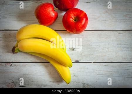 Äpfel und Bananen auf einem Holztisch, Blick von oben Stockfoto
