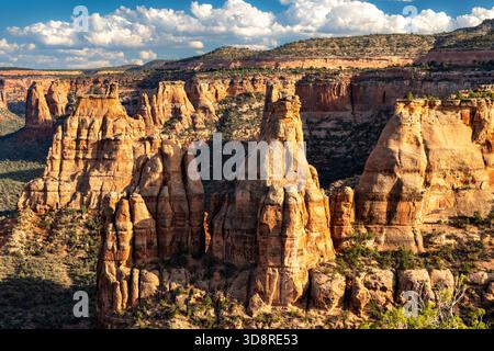 Malerischer Blick auf das Colorado National Monument vom Book Cliffs View. Rote Felsentürme, darunter das Independence Monument, füllen den Canyon unter blauem Himmel Stockfoto