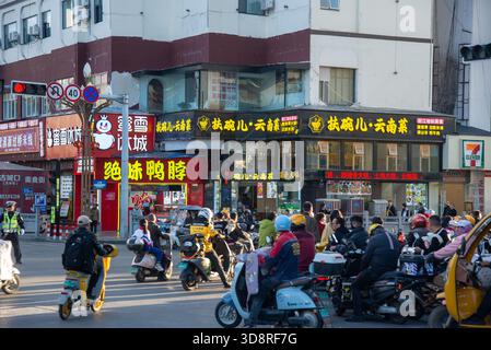 Verkehr mit vielen Elektrorollern in Lijiang, China Stockfoto