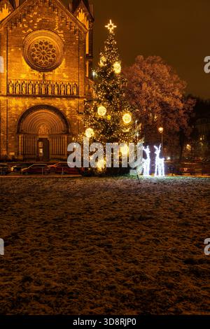 Beleuchtete Tannenbäume und Rentierdekorationen bei Nacht vor einer Kirche in Prag Stockfoto