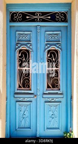 Zweiflügelige Holztür im Vintage-Stil in Hellblau mit raffinierten Metallic-Designs Stockfoto