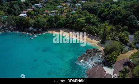 Tropischer Sandstrand und türkisfarbenes Wasser mit Küstenvillen Stockfoto