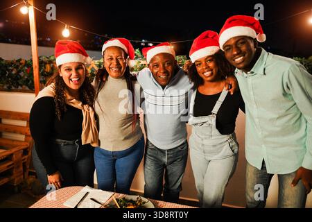 Glückliche afrikanische Familie, die Spaß beim gemeinsamen Essen während der Weihnachtszeit hat - Holiday Concept - Hauptfokus auf das Muttergesicht Stockfoto