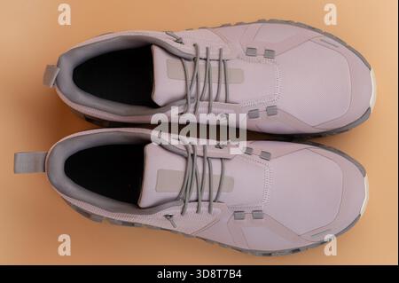 Über Draufsicht auf rosa Sportschuhe isoliert auf braunem Studiohintergrund Stockfoto