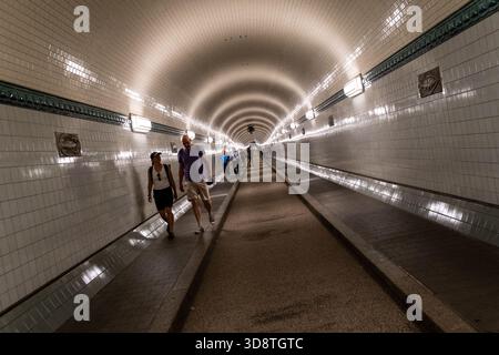 Blick auf Menschen, die im Alten Elbtunnel in Hamburg am 18. Juni 2025 spazieren. Die Szene fängt den historischen Tunnel mit seinen Charakteristika ein Stockfoto
